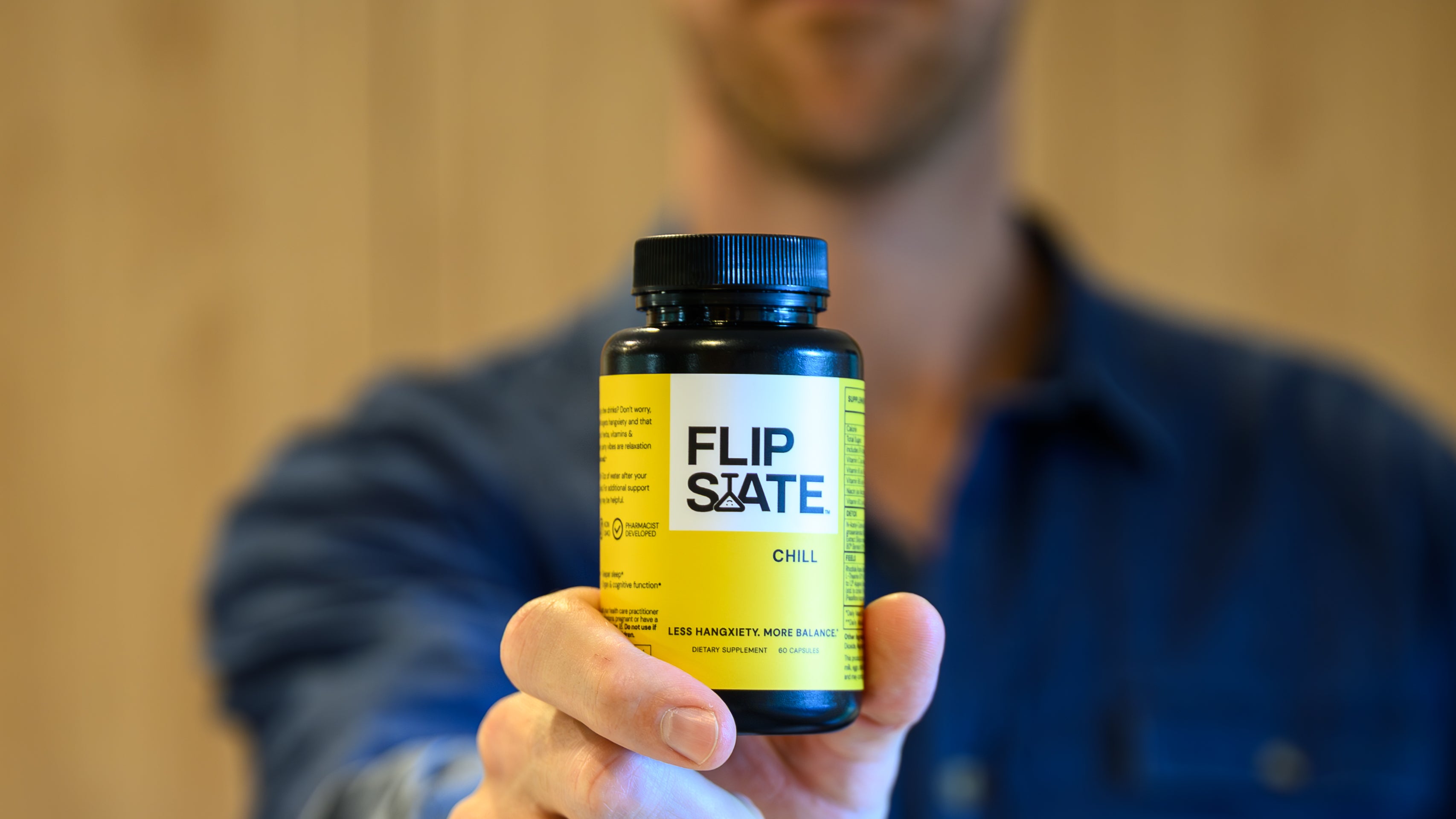Person holding a bottle labeled 'Flip State' which is a hangxiexty relief supplement against a blurred background